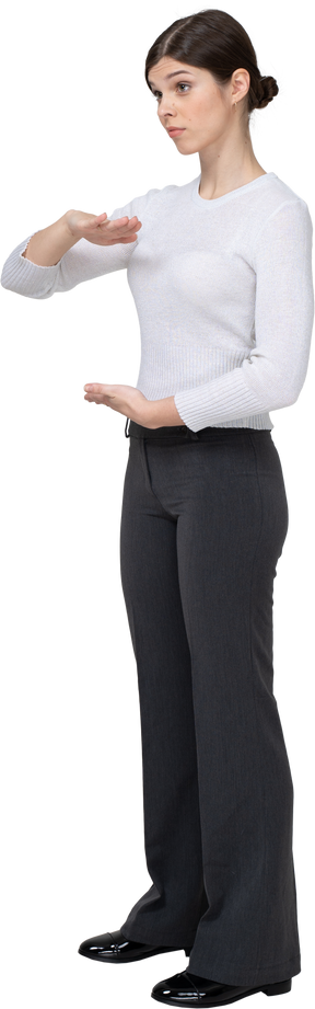 Three-quarter view of a young woman in office clothing showing size of something