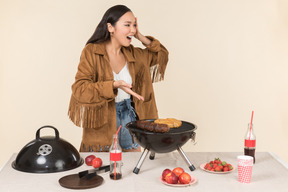 Young asian girl having problem with barbecue