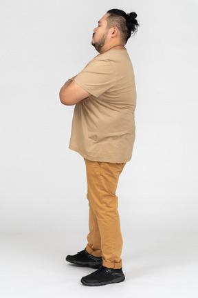 Young asian man standing with his arms crossed