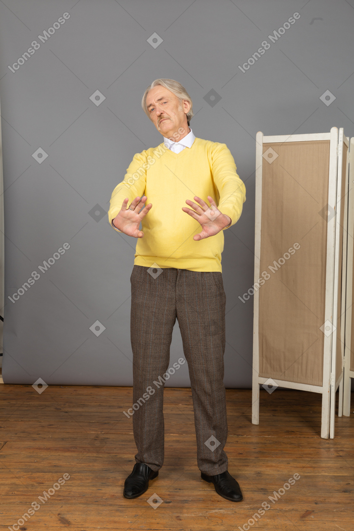 Front view of a displeased old man outstretching his hand