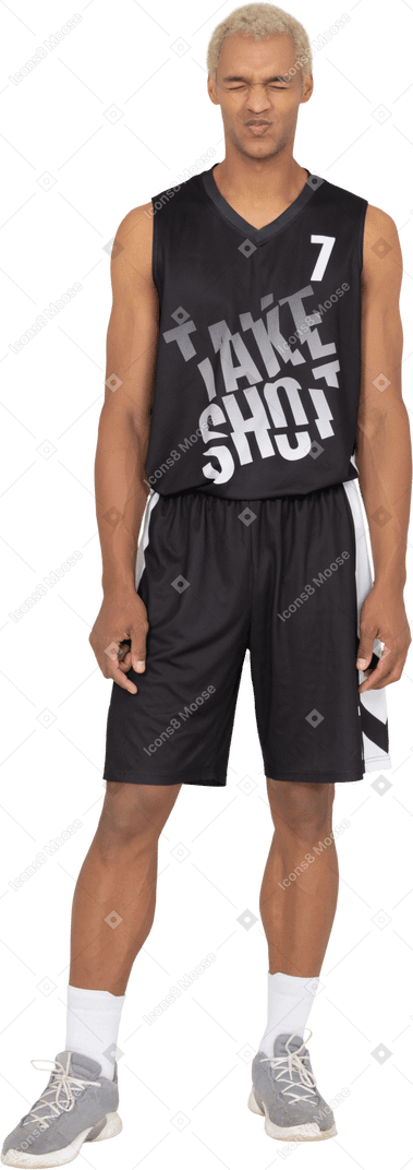 Front view of a displeased young male basketball player clinching his eyes