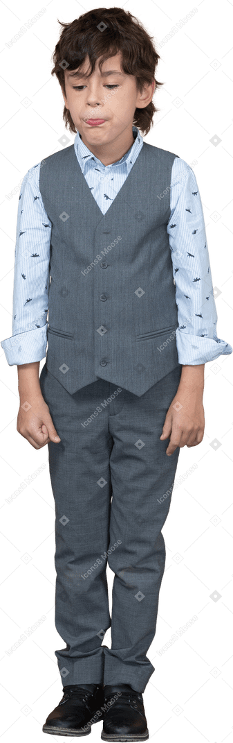 Vista frontal de um menino fofo em um terno cinza fazendo caretas