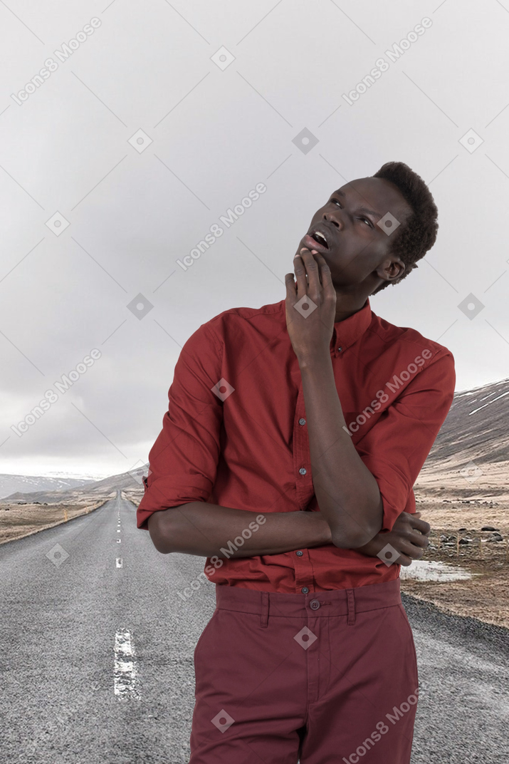Pensive man standing on the side of a road