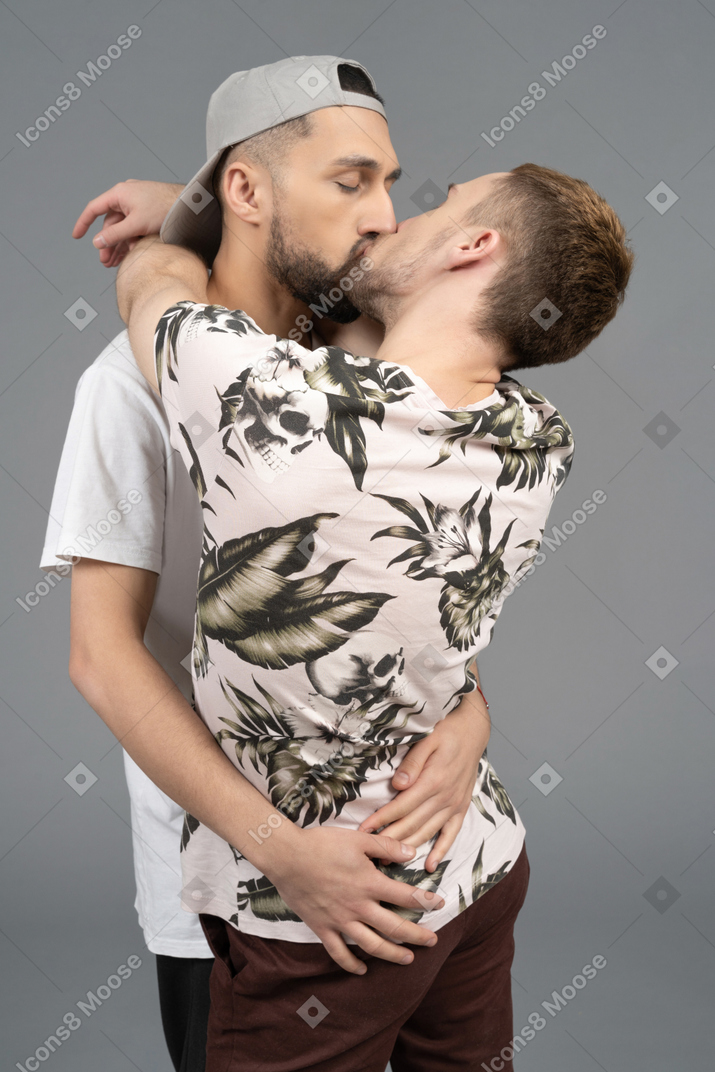 Close-up of a couple of young caucasian men hugging and kissing passionately