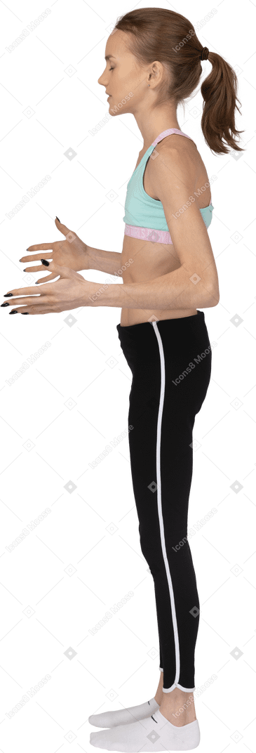 Vista laterale posteriore di una ragazza adolescente in abiti sportivi alzando le mani e litigando