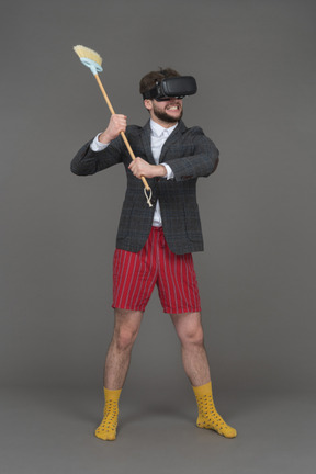 Man in vr headset swinging a broom