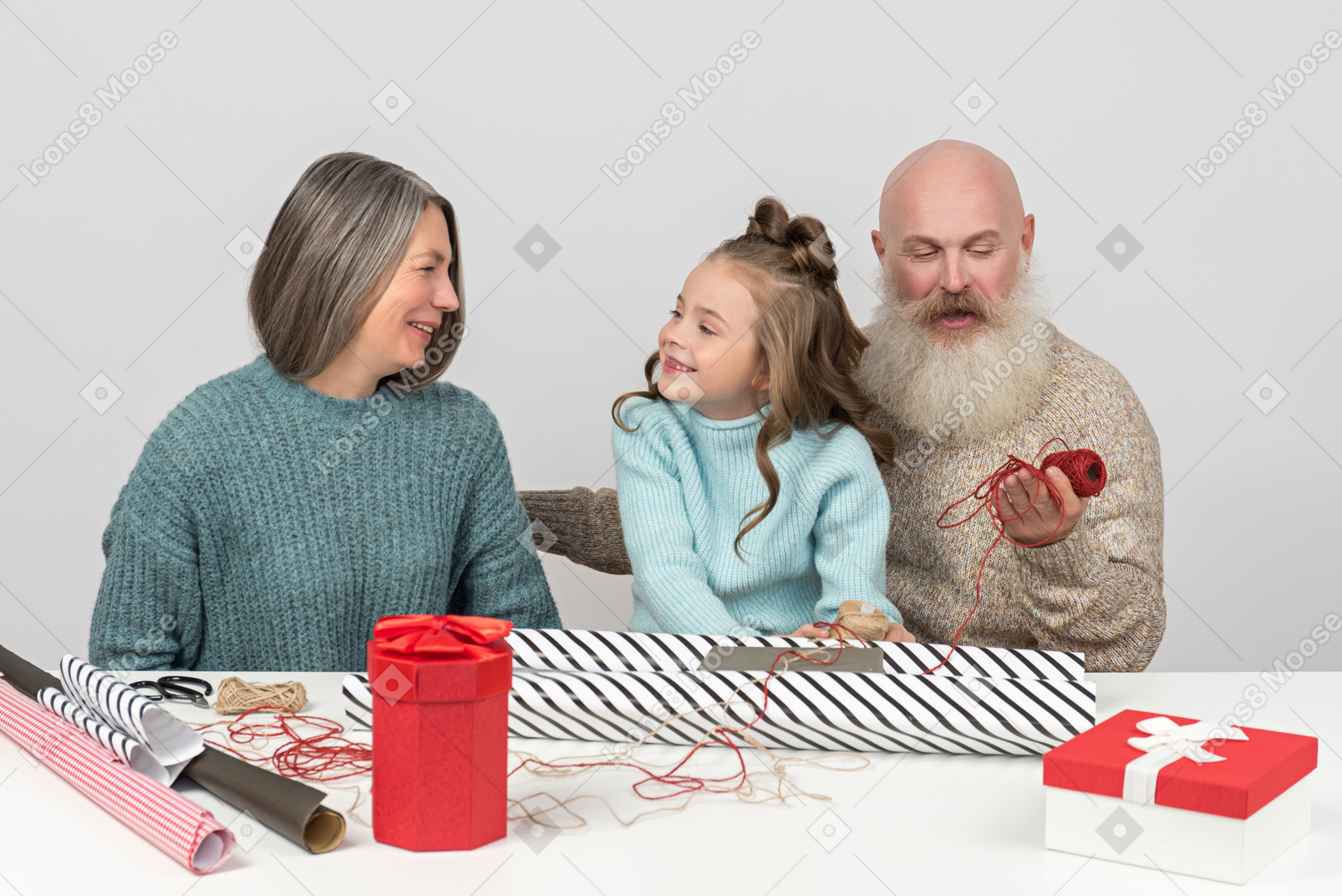 Grandparents and granddaughter wrapping christmas gifts