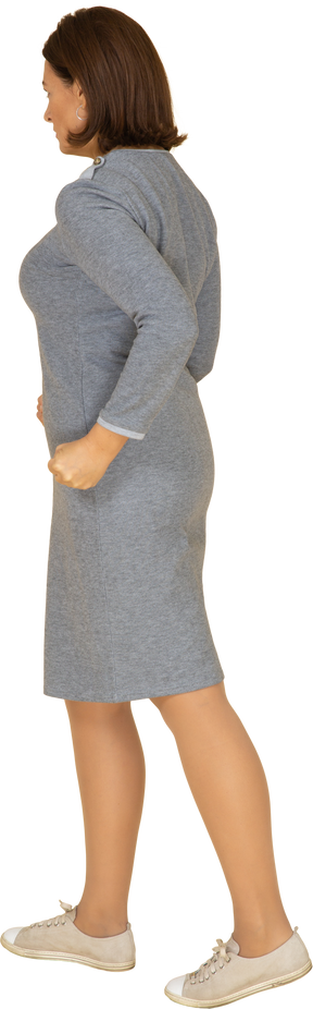 Vista lateral de uma mulher zangada em um vestido cinza