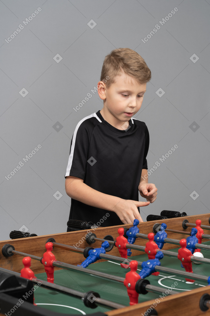 一个男孩玩桌上足球的四分之三视图