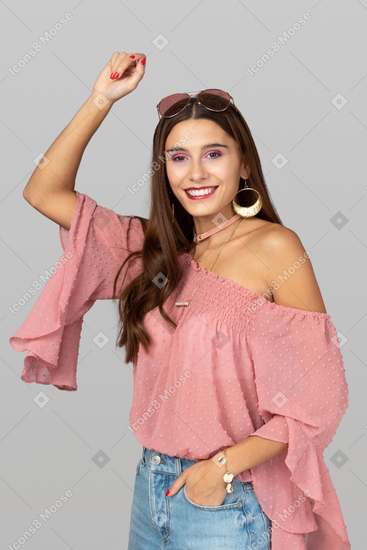 Beautiful young woman in boho style holding her hands up