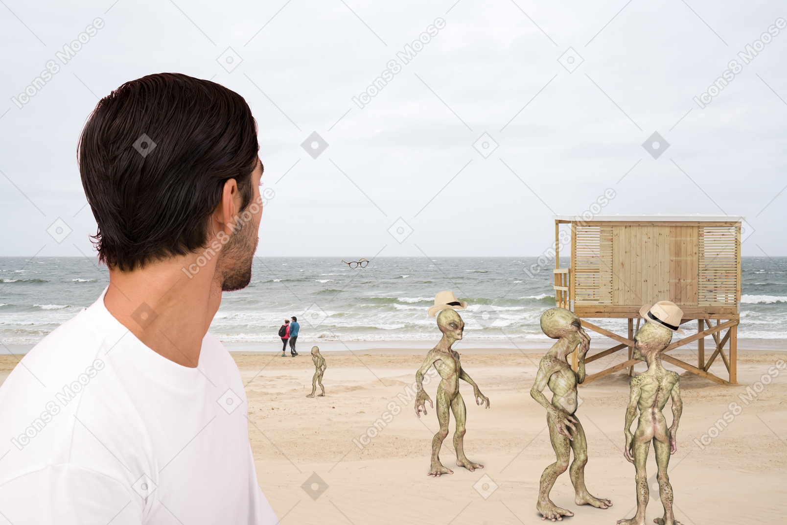 A man on a beach looking at a group of aliens