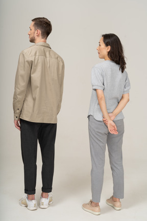 Three-quarter back view of young couple standing