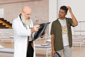 Pensive man and doctor looking at x-ray