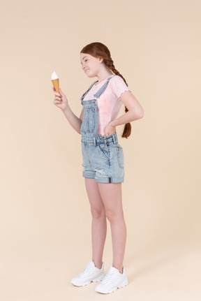 Teenager girl looking at ice cream she's holding