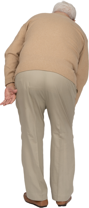 Retrovisione di un vecchio in abiti casual che si piega e tocca il ginocchio