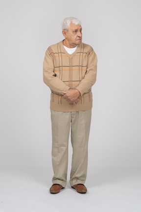 Front view of an old man in casual clothes looking aside