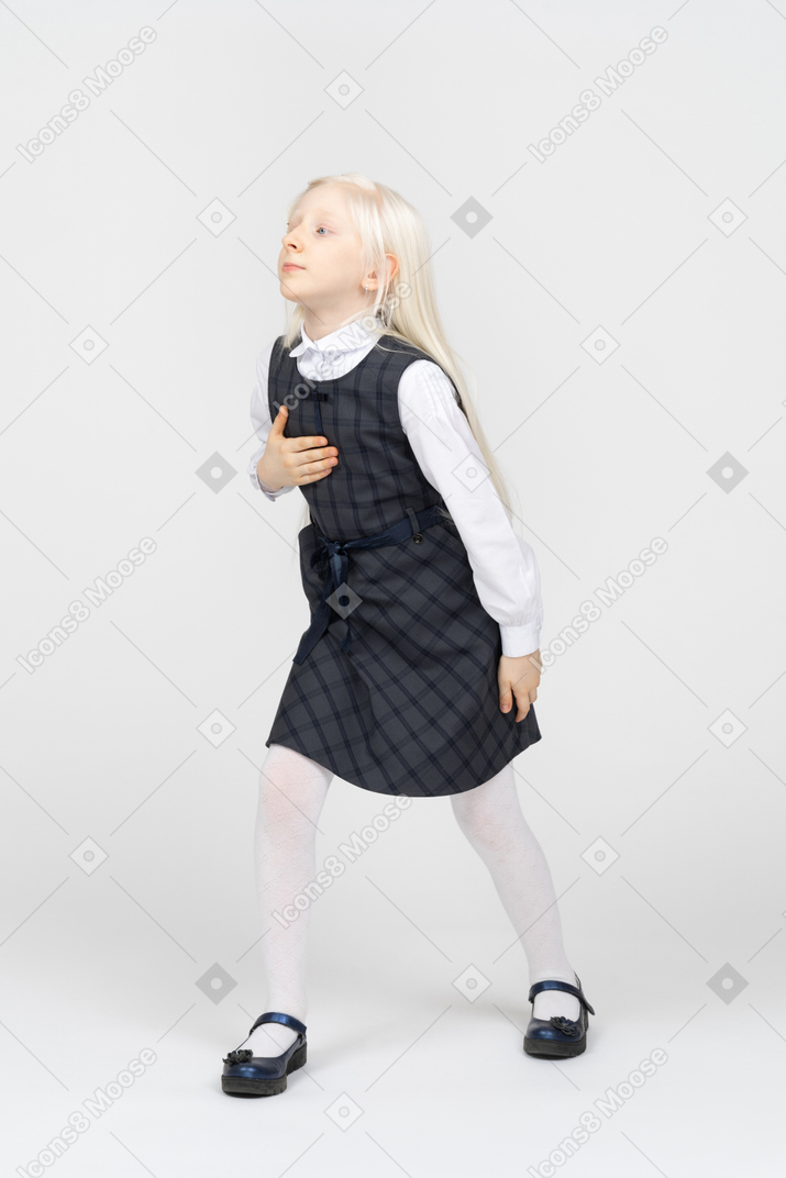 Schoolgirl stepping forward with hand on chest