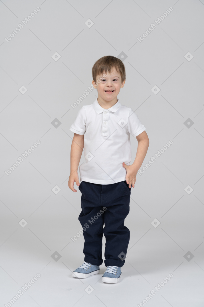 Smiling little boy standing with arms at sides