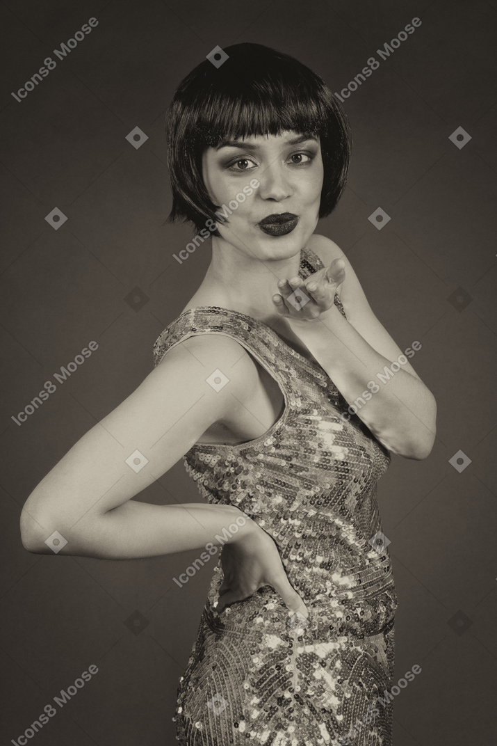 Glamorous young woman blowing a kiss