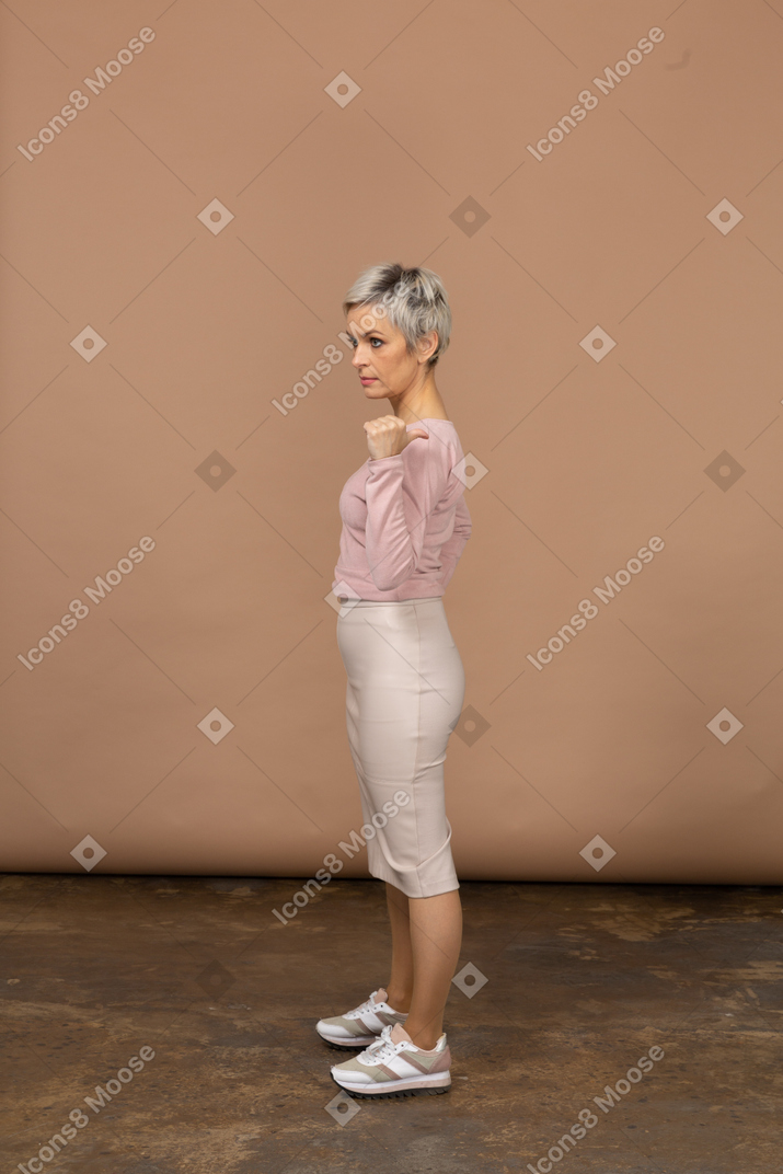 Vista lateral de uma mulher com roupas casuais apontando com o dedo