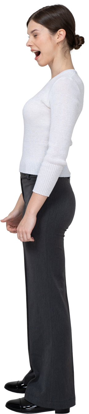 Side view of a yawning young woman in office clothing