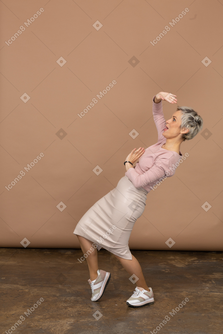 Vue latérale d'une femme heureuse dans des vêtements décontractés dansant