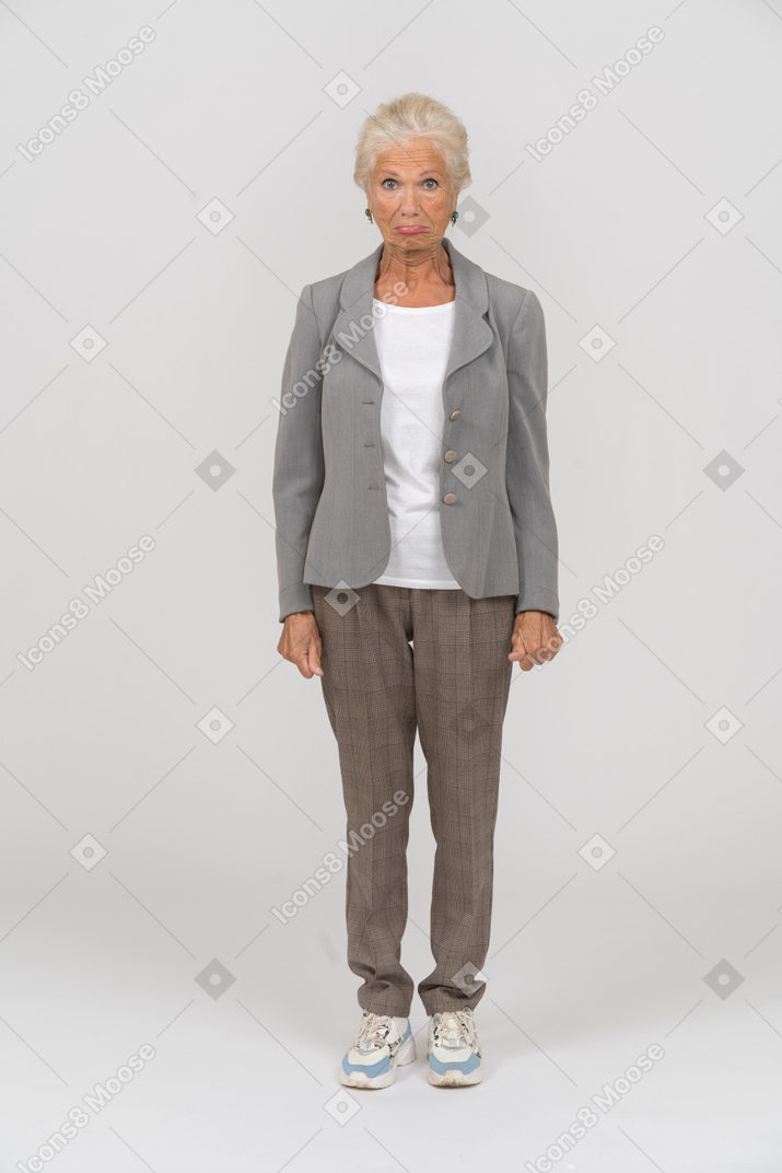 Vista frontal de uma velha com uma jaqueta cinza olhando para a câmera