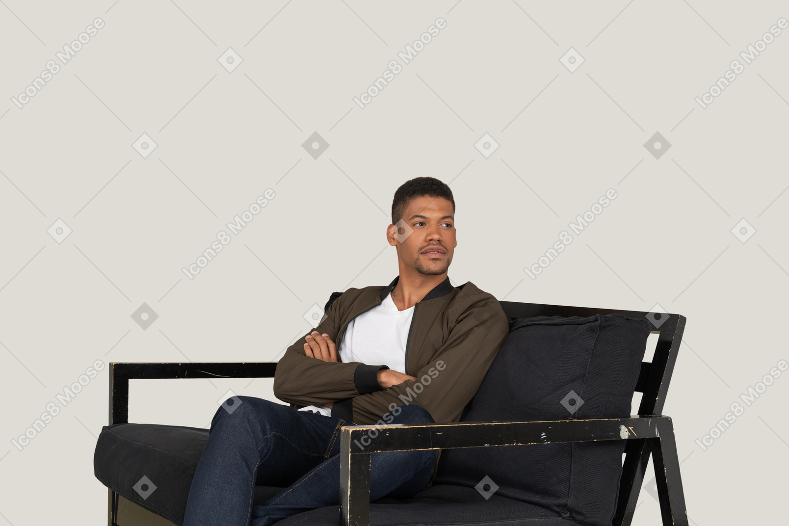 Young man sitting on the sofa with his hands crossed