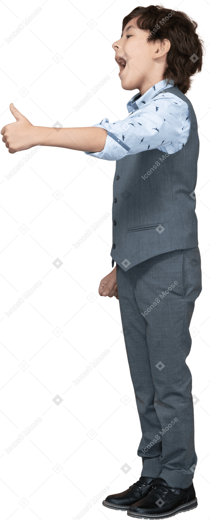 Side view of a cute boy in grey suit showing thumb up