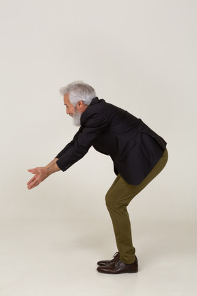 Side view of a man in a jacket reaching down