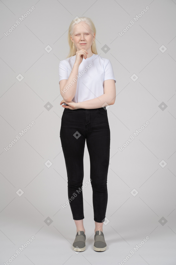 Mujer joven pensativa en ropa casual tocando su barbilla