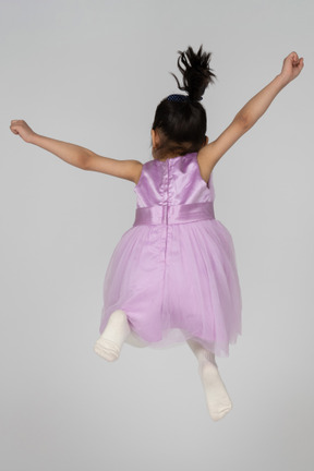 Chica con vestido rosa saltando