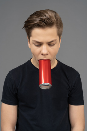 Close-up a male model holding red can with his mouth