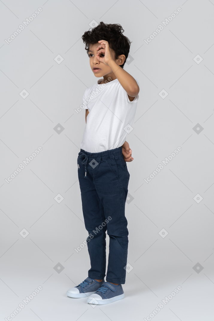 A boy looking through a finger ring
