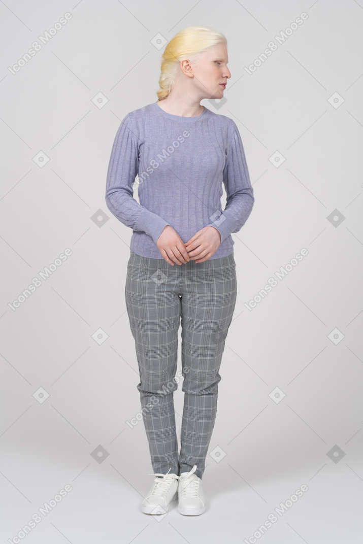 Vista frontal de una mujer joven con ropa informal mirando a la derecha