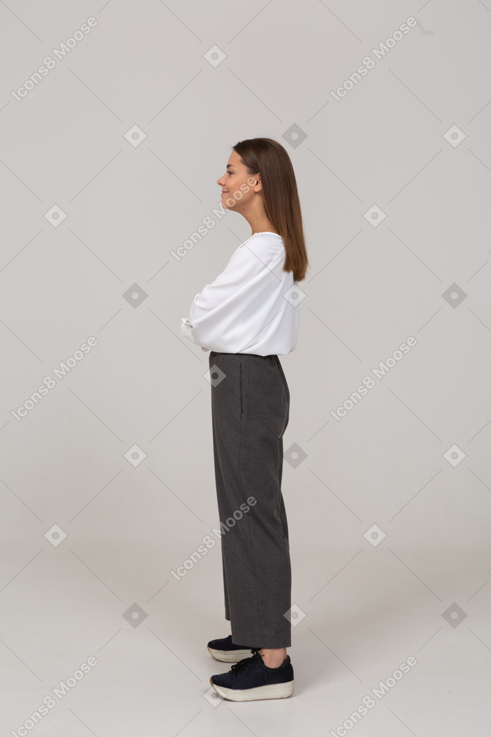Side view of a smiling young lady in office clothing looking aside