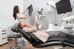 Longitud total de una mujer dentista y su paciente mirando rayos x