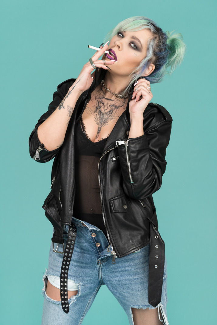 Punk woman with turquoise hair holding a cigarette
