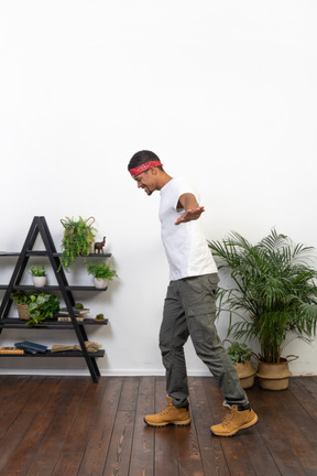 Good looking young man posing on the background of the apartment