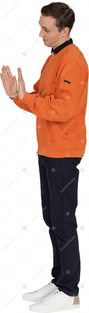 Young man in orange sweatshirt standing