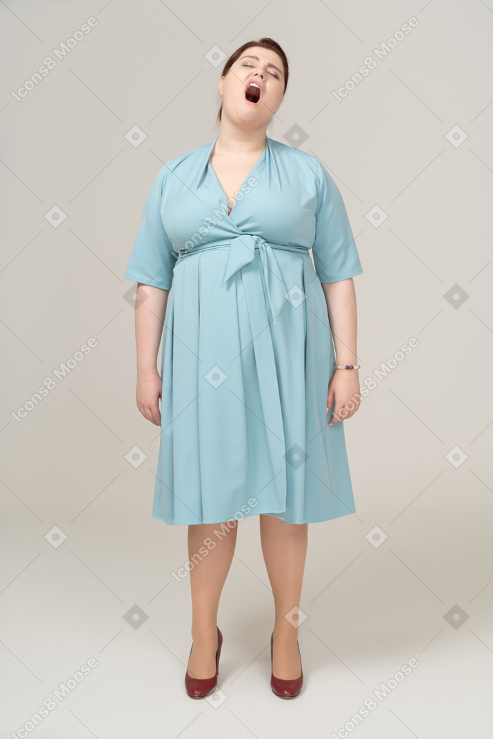 파란 드레스를 입고 하품을 하는 여자의 전면 모습