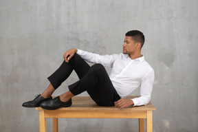 Man in formal clothes lying on a table