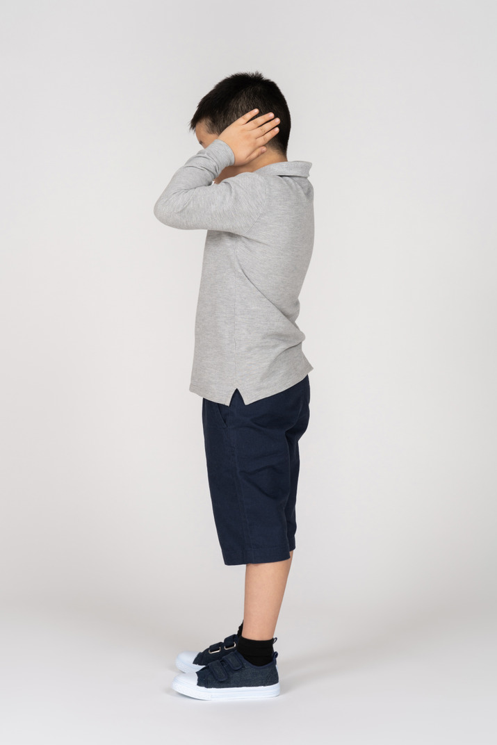 Boy covering his ears in profile