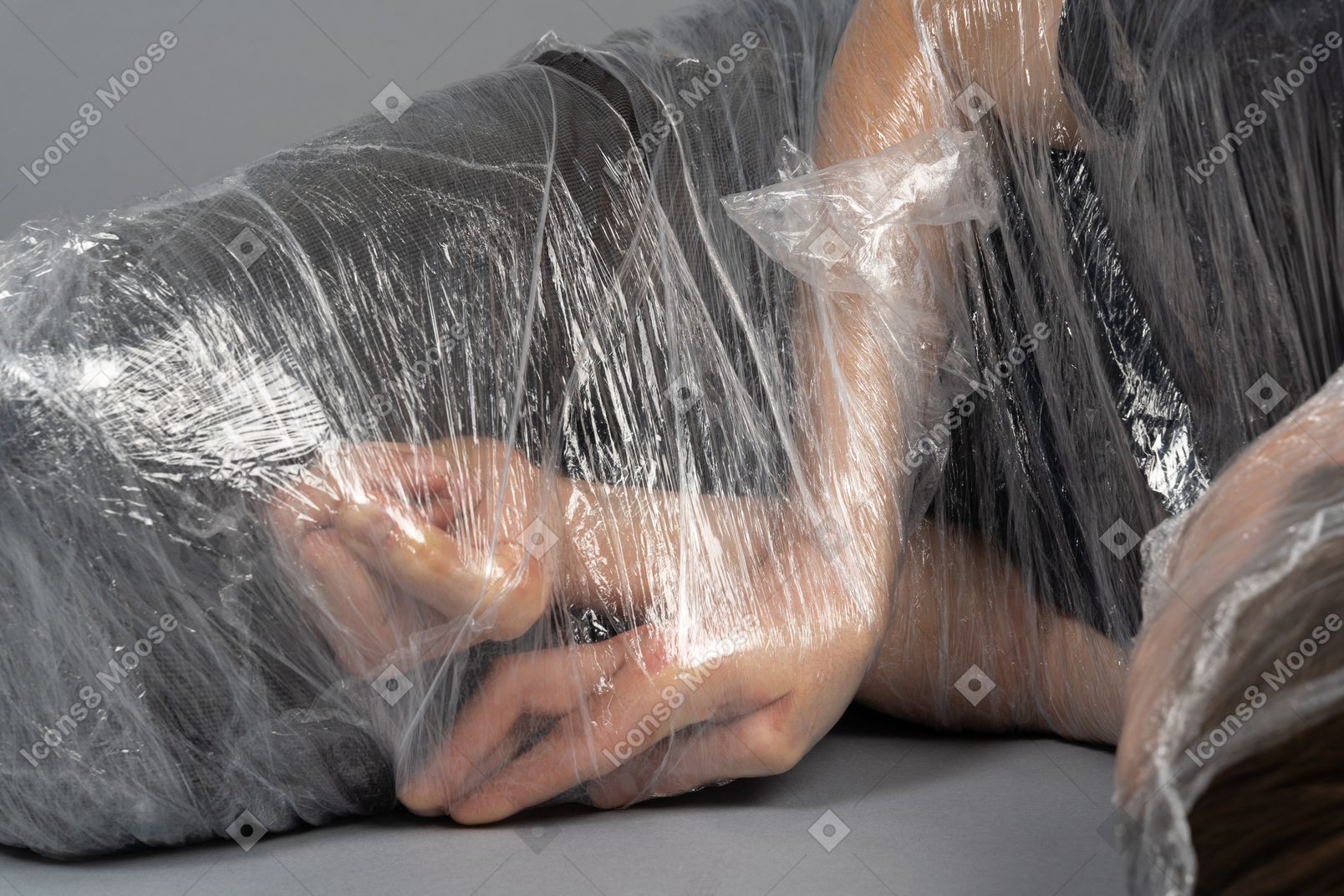 Hands of a young man wrapped in plastic