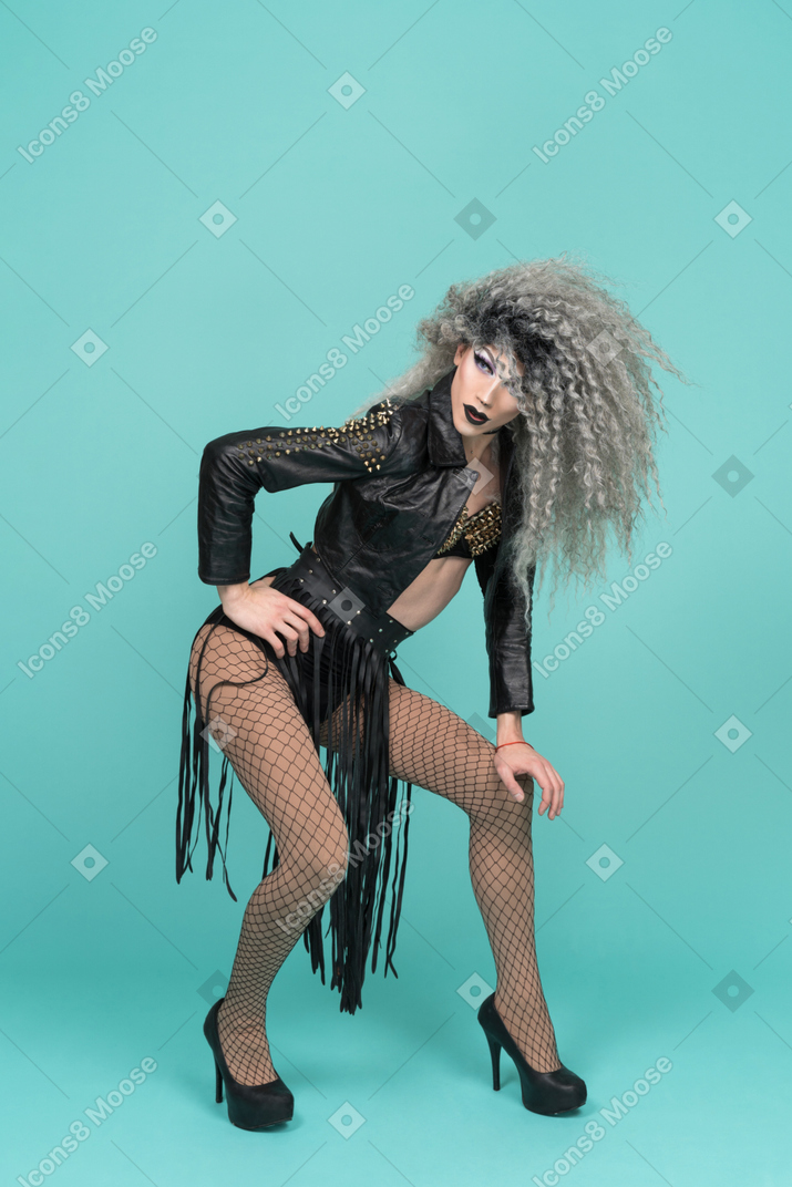 Drag queen com cabelo bagunçado fazendo meio agachamento