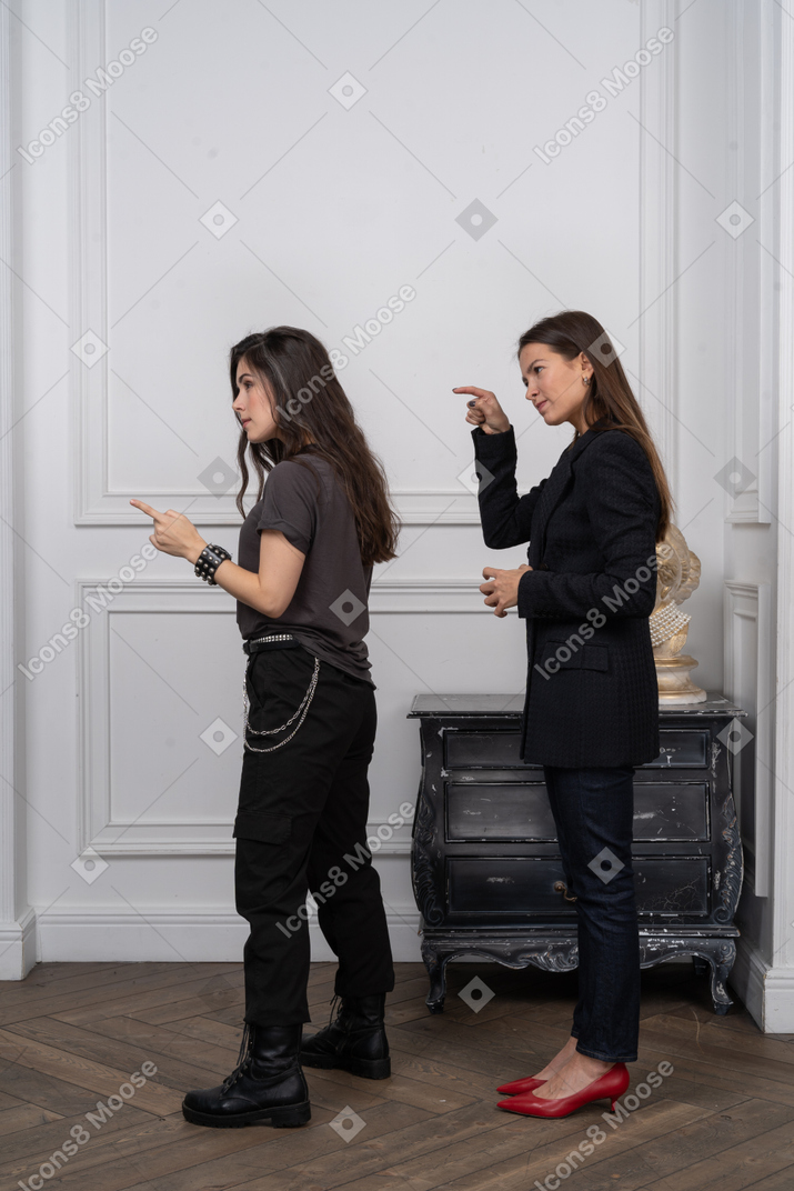 Two women pointing at something