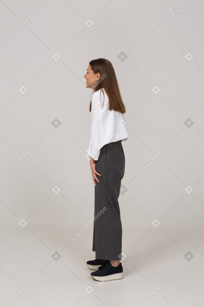 Side view of a smiling young lady in office clothing
