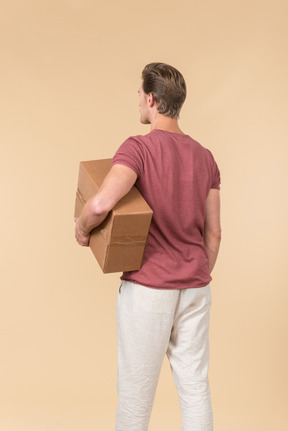 Delivery guy holding box and standing back to camera