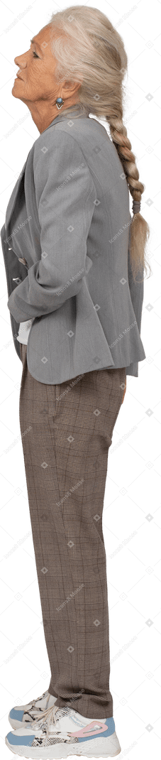 Vista lateral de una anciana en traje que sufre de dolor de estómago