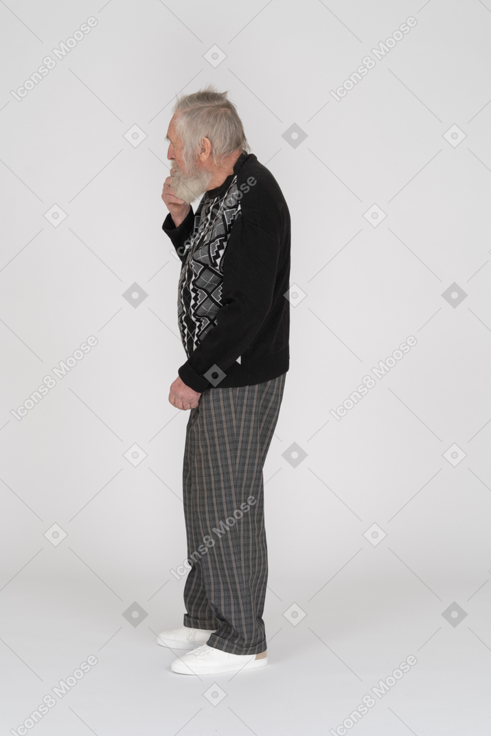 Вид сбоку думающего пожилого мужчины, держащего руку на подбородке